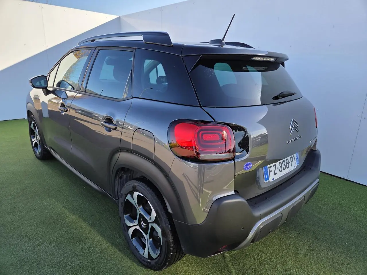 Vue 3/4 arrière droite d'un Citroën C3 Aircross gris platinium avec toit noir perlé et jantes alliage 17 pouces.