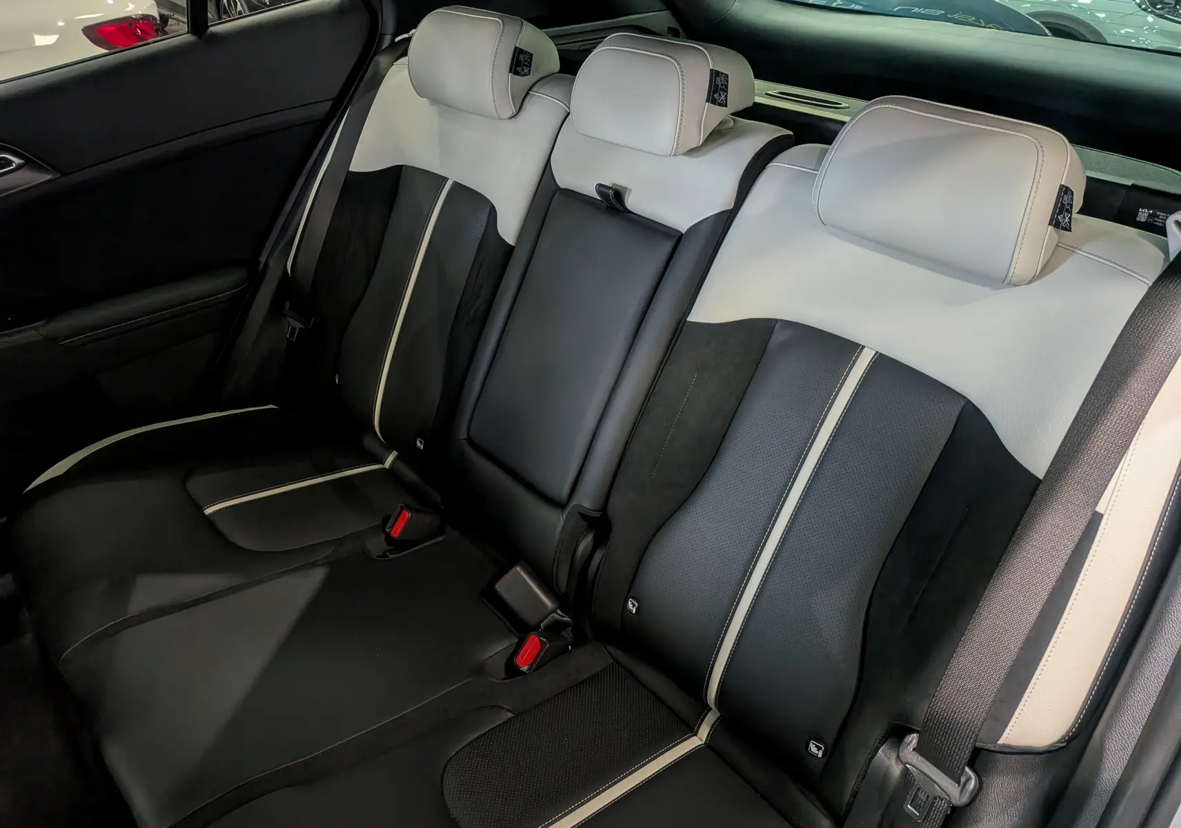 Vue intérieure sur les sièges arrière bicolores noir et gris clair du Kia Sportage 2025 GT Line hybride.