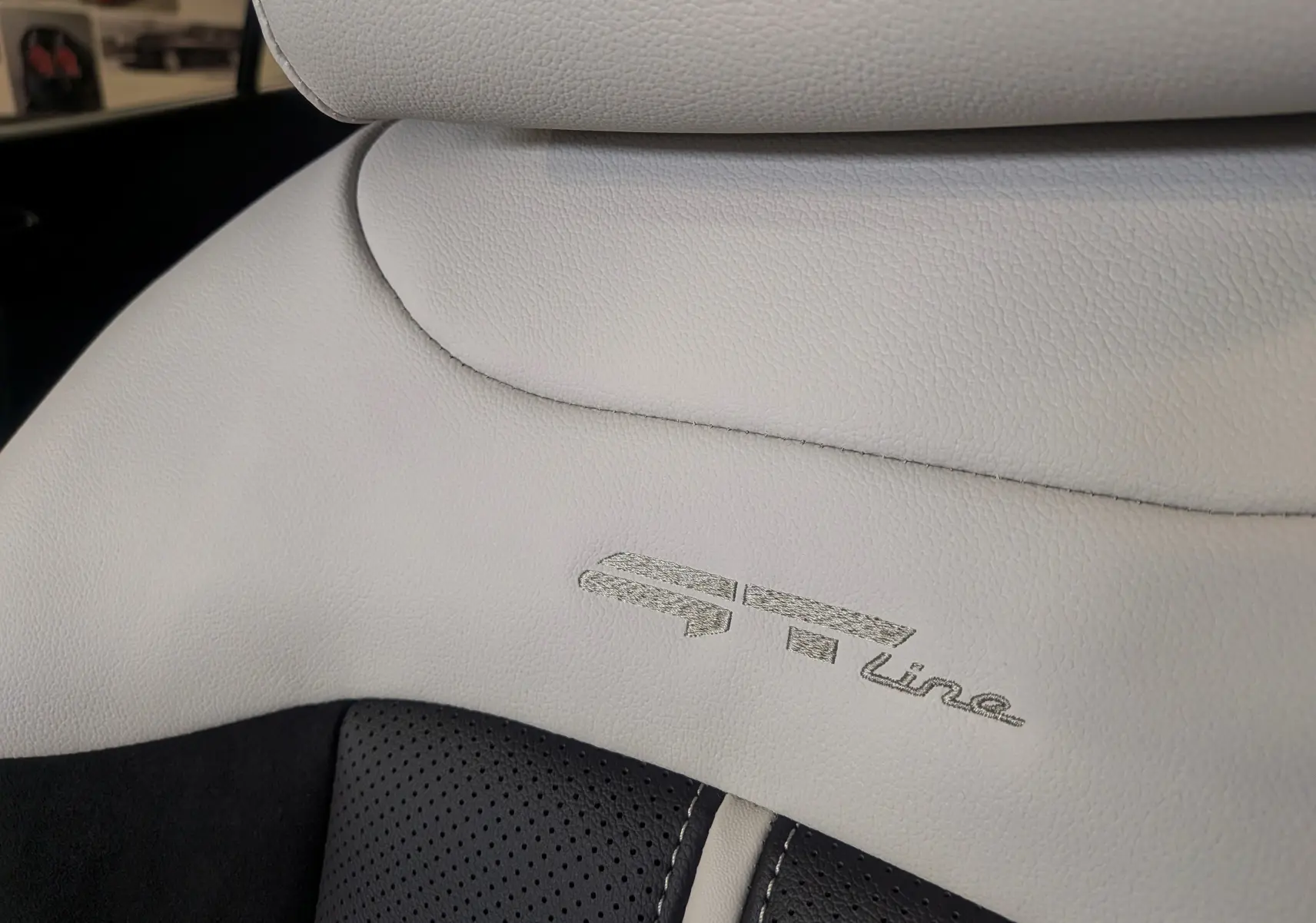 Gros plan sur le cuir clair perforé et embossé GT Line du siège avant du Kia Sportage 2025.