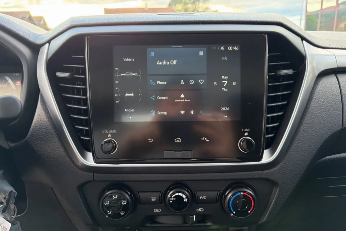 Vue rapprochée de l'écran tactile central et des commandes de climatisation du tableau de bord d'un Isuzu D-MAX blanc.