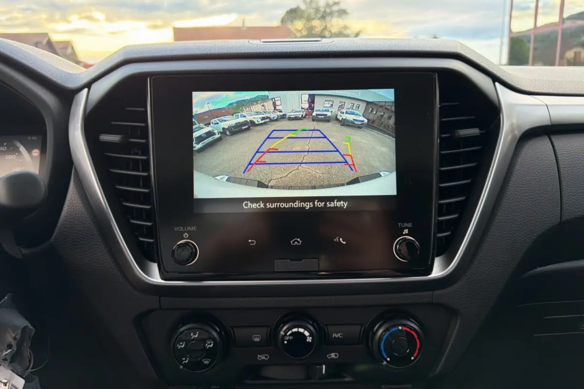 Vue intérieure centrée sur l'écran tactile affichant la caméra de recul du pick-up Isuzu D-MAX blanc.