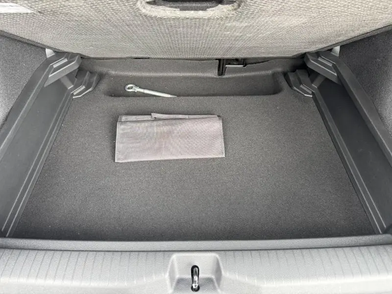 Coffre ouvert du Citroën C3 Aircross 2026, vue de dessus, intérieur noir avec pochette et crochet métallique.