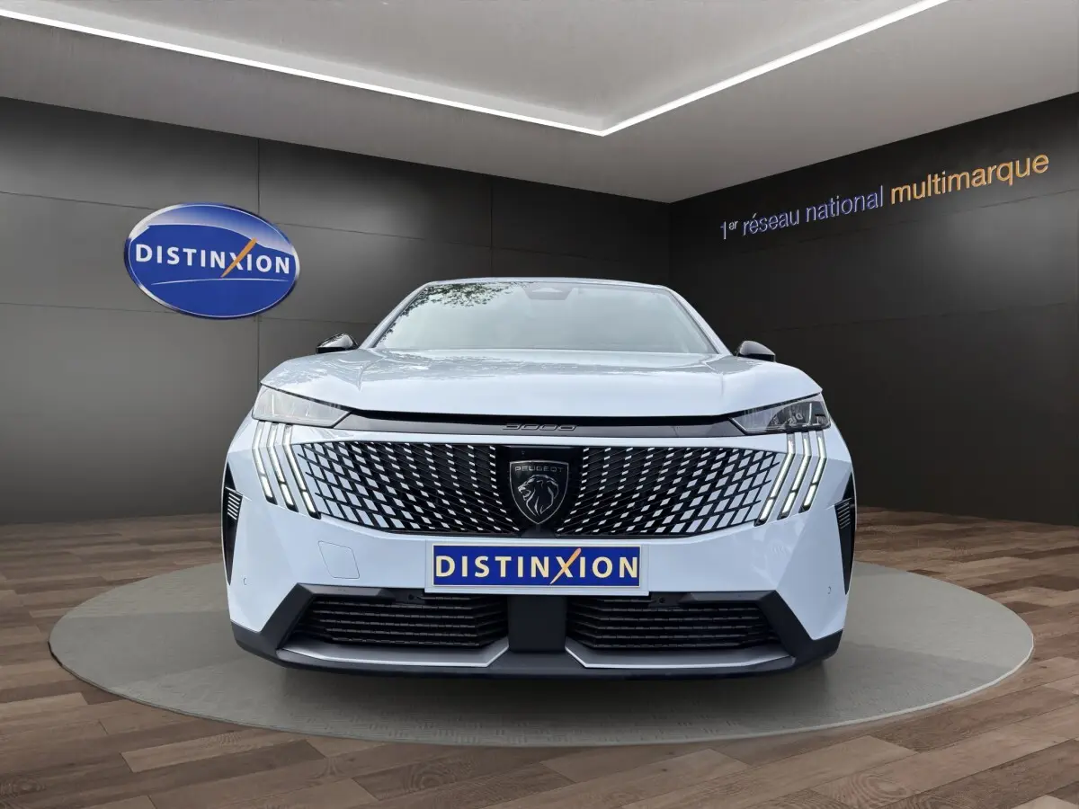 Vue frontale d'un Peugeot 3008 blanc avec calandre noire à motif géométrique et feux LED verticaux distinctifs.