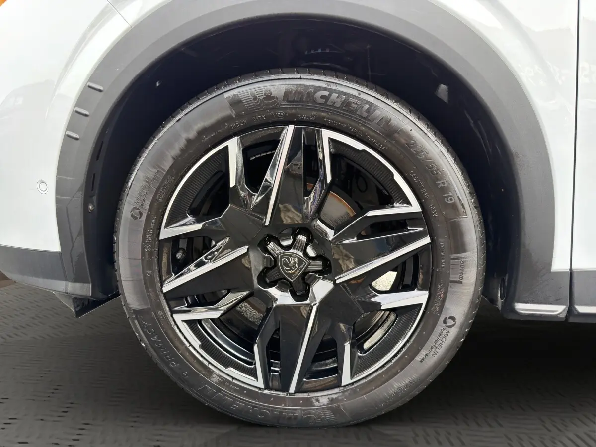 Gros plan sur la roue avant droite du Peugeot 3008 blanc, jante alliage noire et chromée avec pneu Michelin.