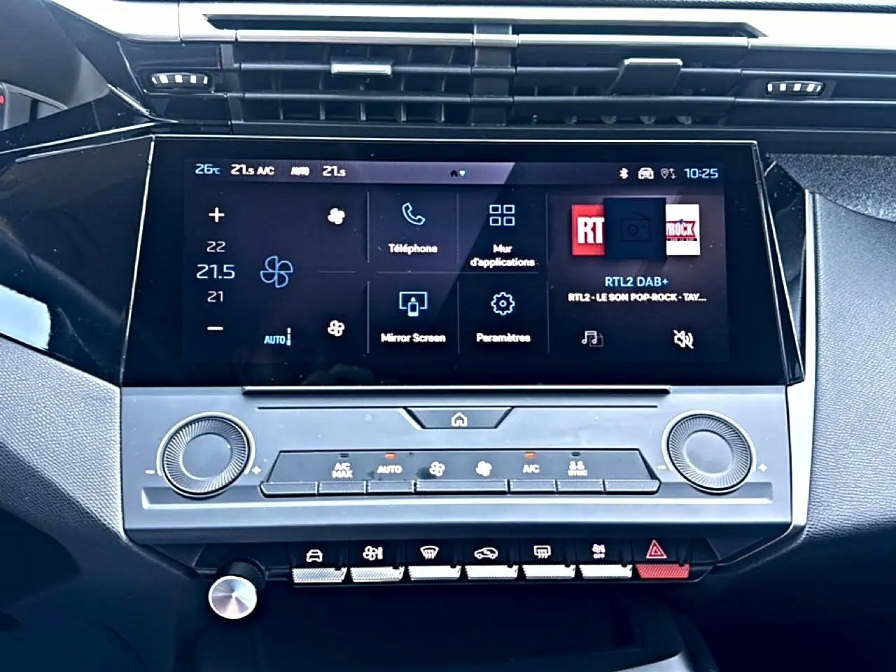 Gros plan sur l’écran tactile central et la console de la Peugeot 308 gris, affichant les commandes de climatisation et multimédia.