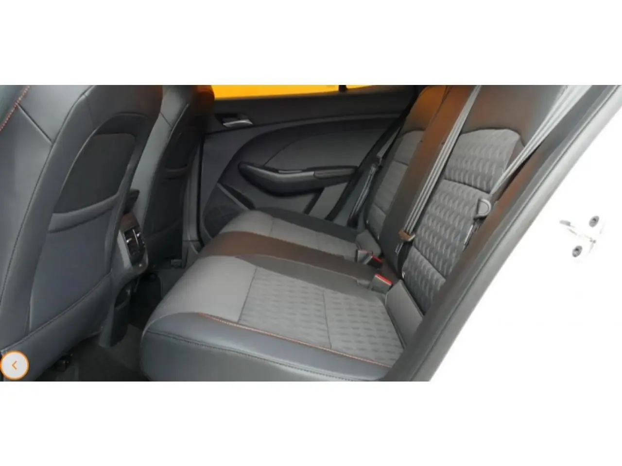 Vue intérieure du siège arrière côté droit du MG3 1.5 HYBRID+ 195 LUXURY blanc, avec sellerie bi-matière grise et coutures orange.