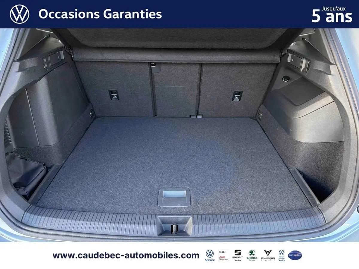 Coffre ouvert d’un Volkswagen Tiguan argent Dolomite, vue de l’arrière montrant l’espace de chargement vide.