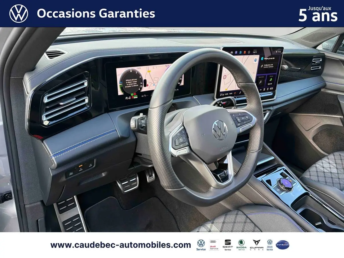 Intérieur avant droit du Volkswagen Tiguan eHybrid 2025 argent Dolomite, volant sport et écran tactile large visible.