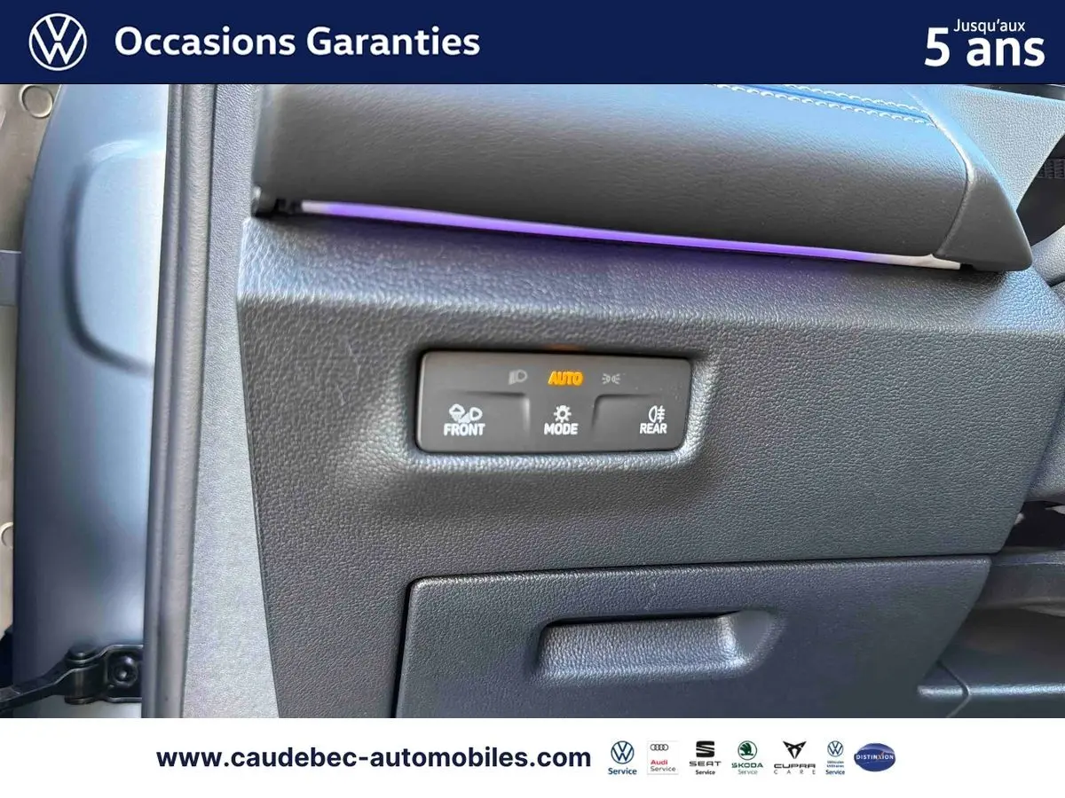 Détail du tableau de bord du Volkswagen Tiguan 2025 avec commandes d'éclairage et bandeau lumineux violet.