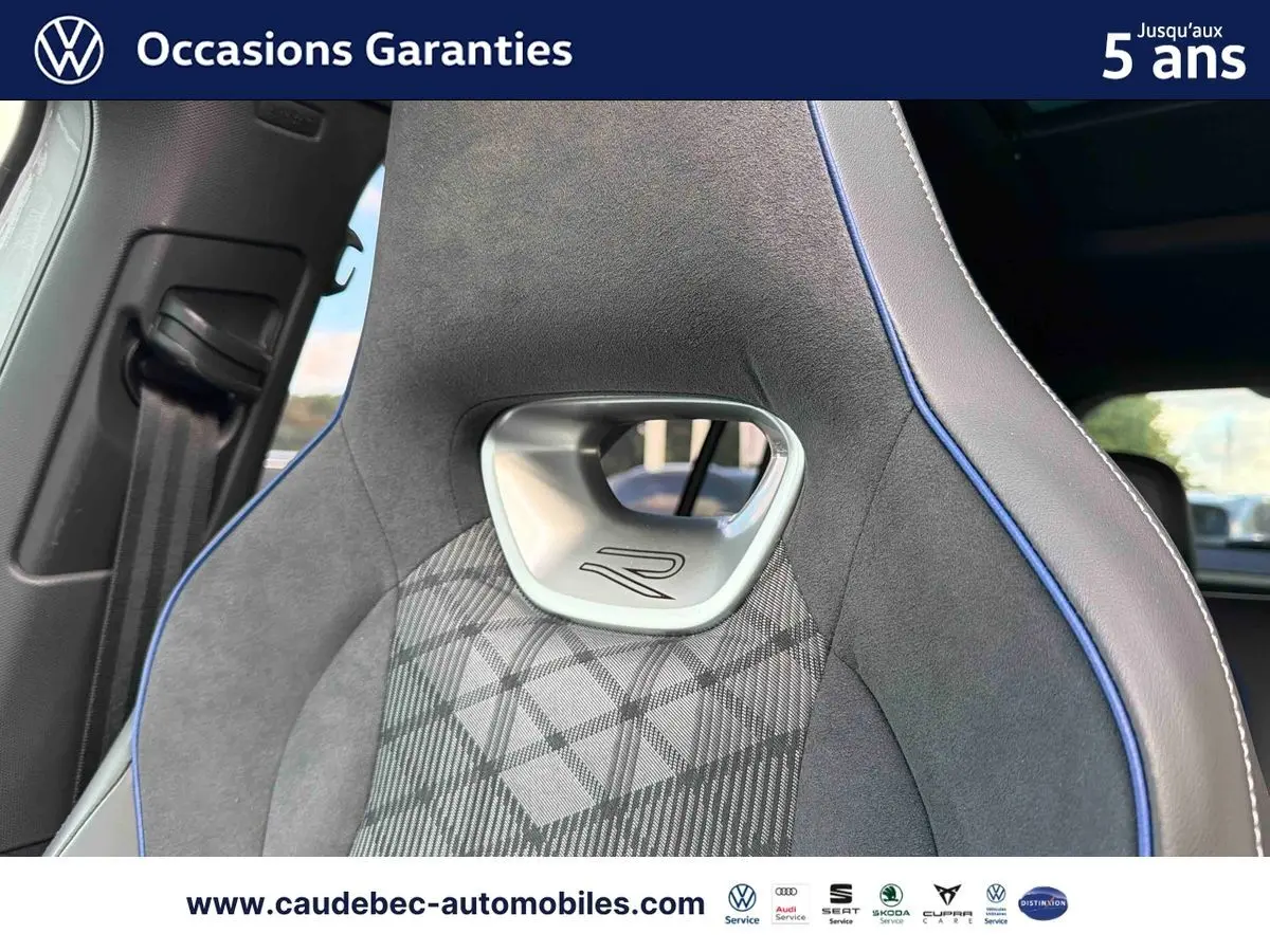 Gros plan sur le siège avant sport gris avec surpiqûres bleues et logo R du Volkswagen Tiguan 2025.