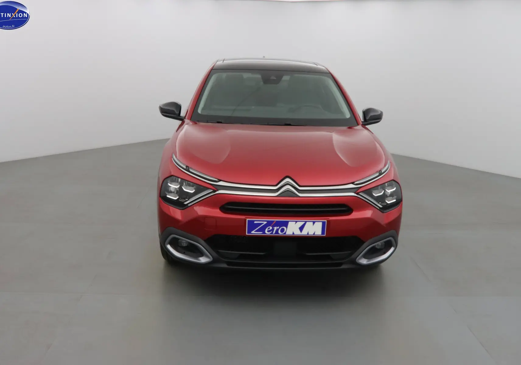 Vue frontale d'une Citroën C4 X rouge Elixir Metal avec feux LED et calandre chromée distinctive.