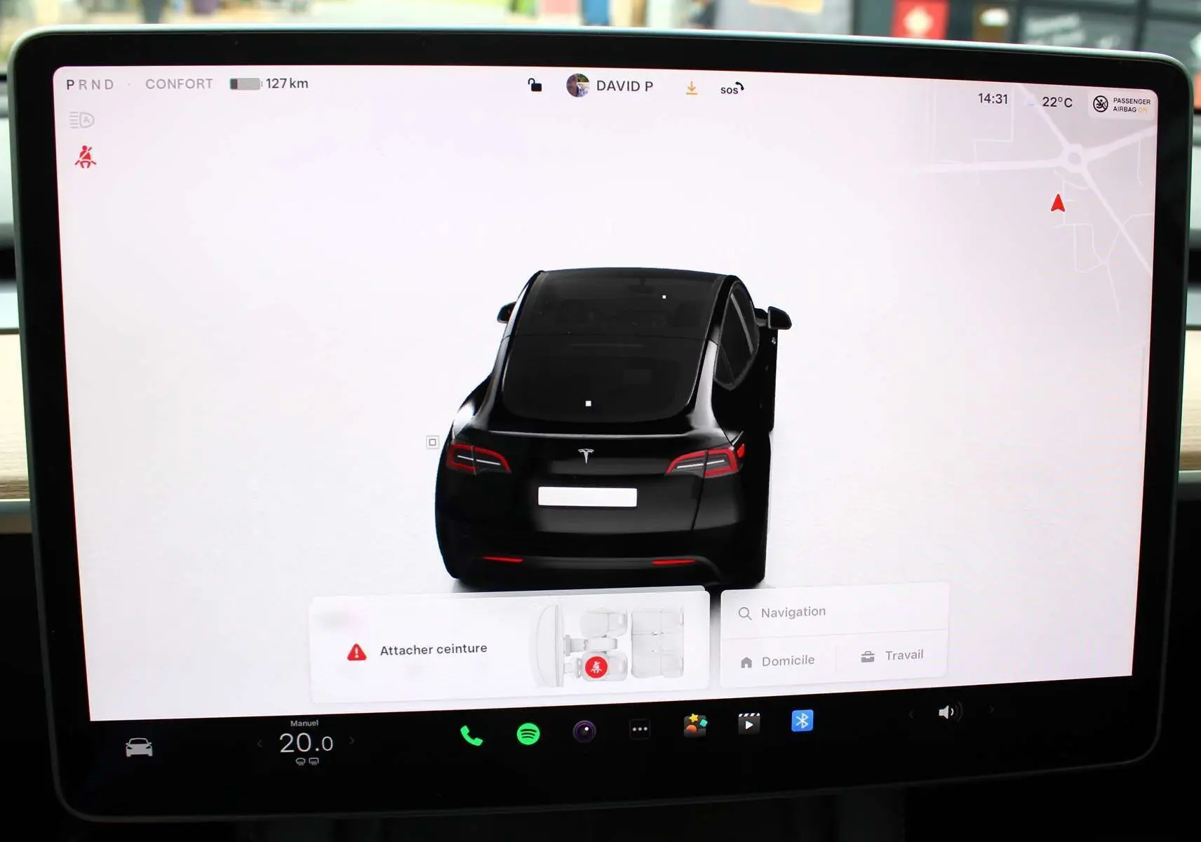 Vue arrière virtuelle du Tesla Model Y noir métal 2024 affichée sur l'écran central avec porte arrière droite ouverte.