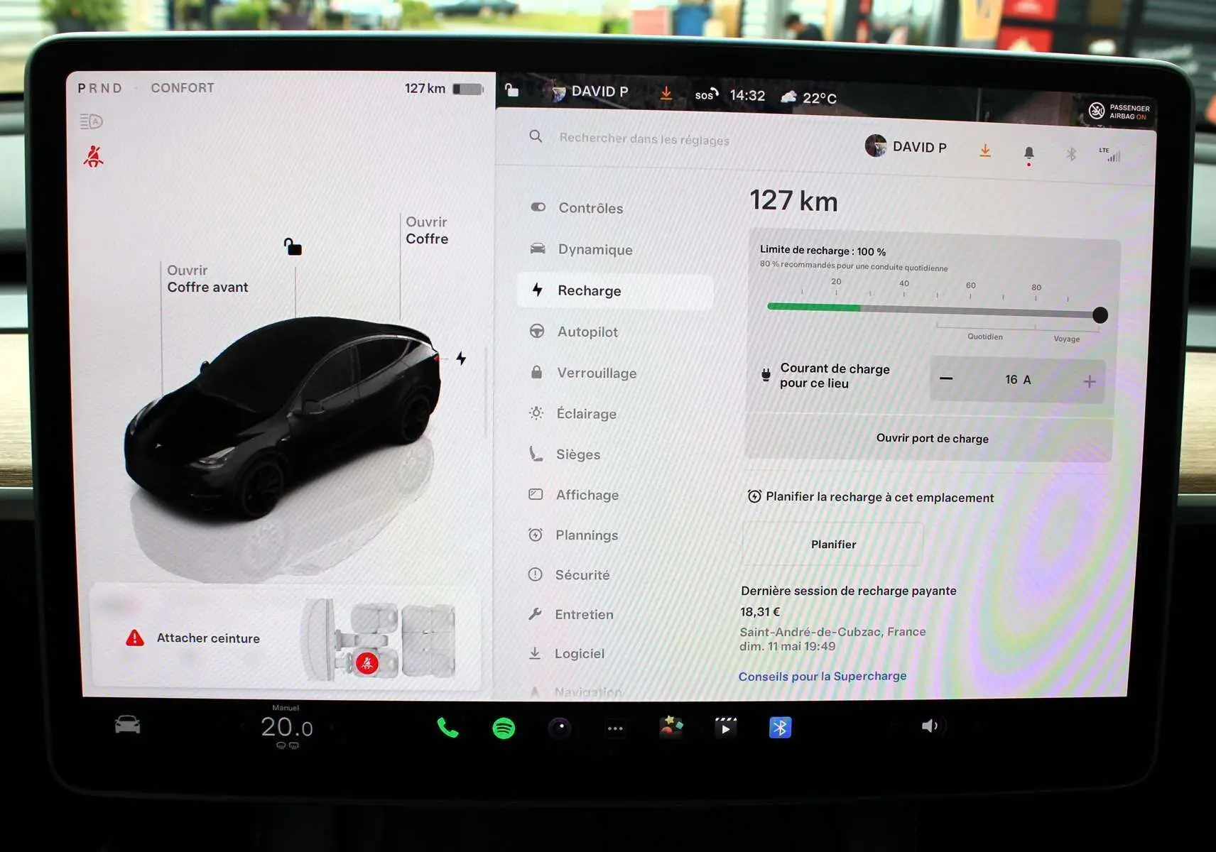 Écran tactile central de la Tesla Model Y 2024 noir métal montrant l'interface de recharge et les options du véhicule.