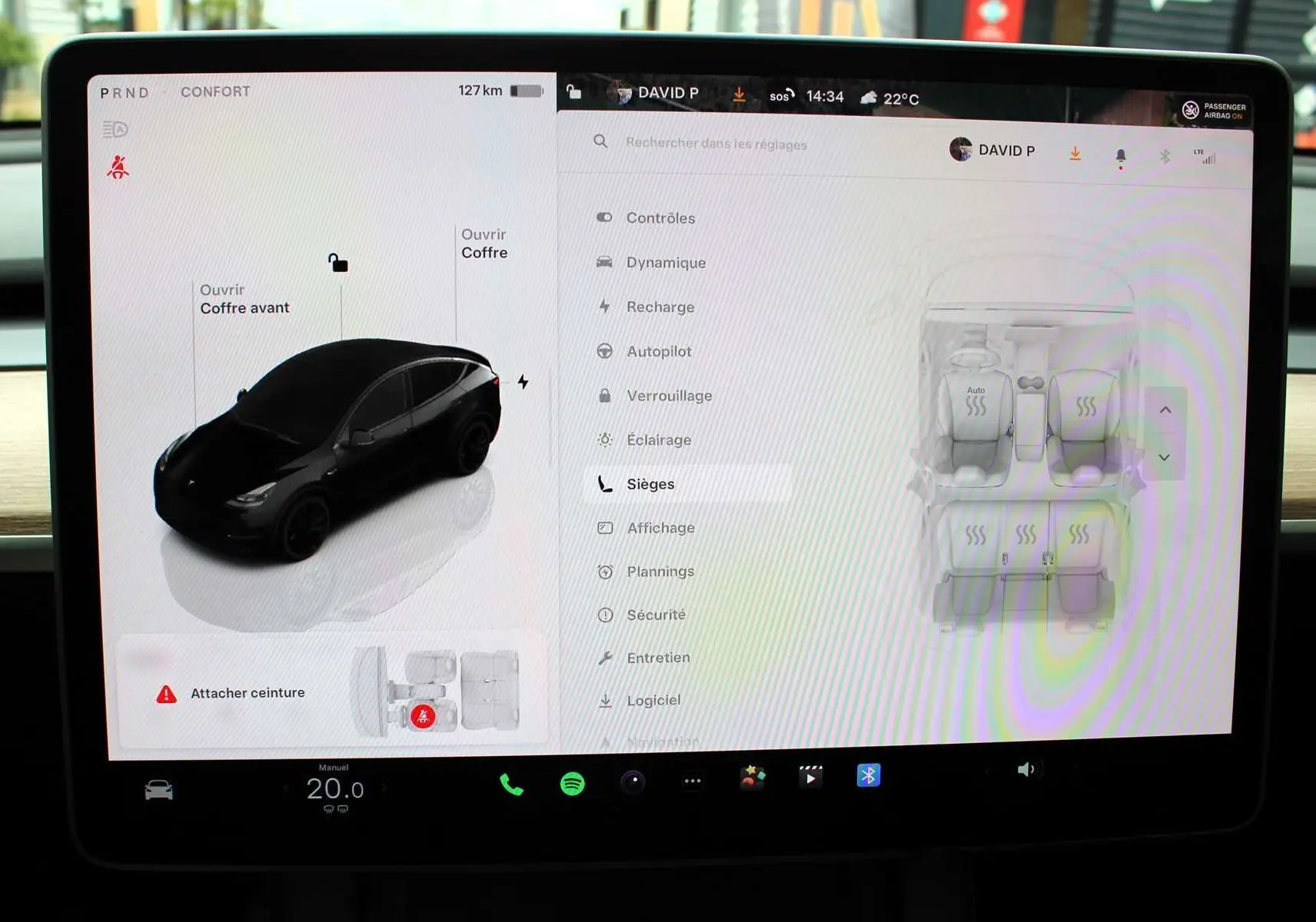Écran tactile central montrant la Tesla Model Y noire en 3D et les réglages des sièges chauffants en vue intérieure.