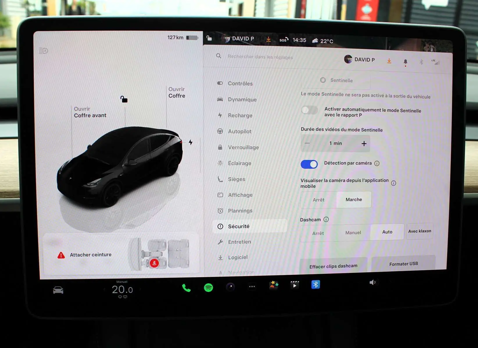 Écran tactile intérieur de Tesla Model Y noir métal 2024 montrant les réglages de sécurité et l'interface du véhicule.