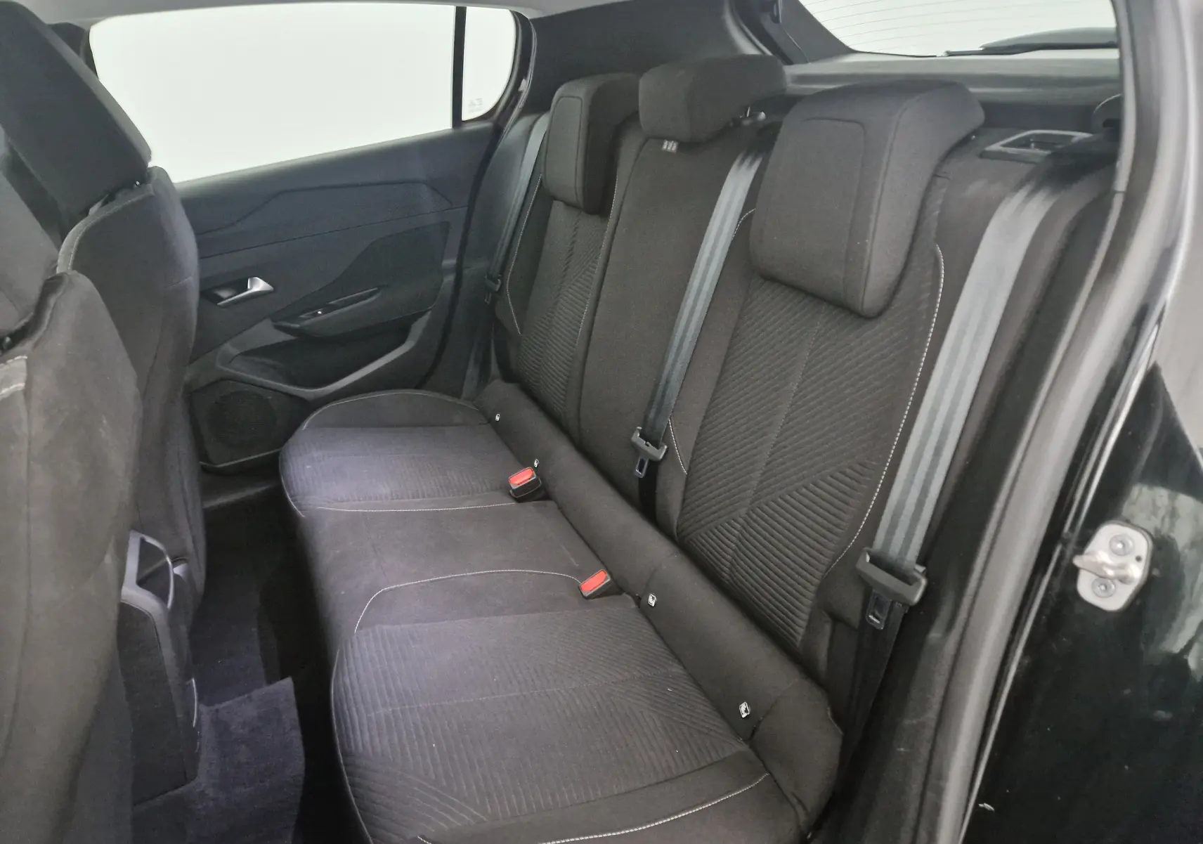 Vue plongeante sur la console centrale noire de la Peugeot 308 2022, montrant levier de vitesses automatique et commandes intégrées.