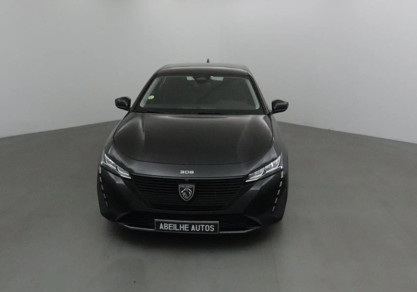 Profil côté gauche d'une Peugeot 308 noire de 2022, finition Active Pack, garée en extérieur sur un parking.