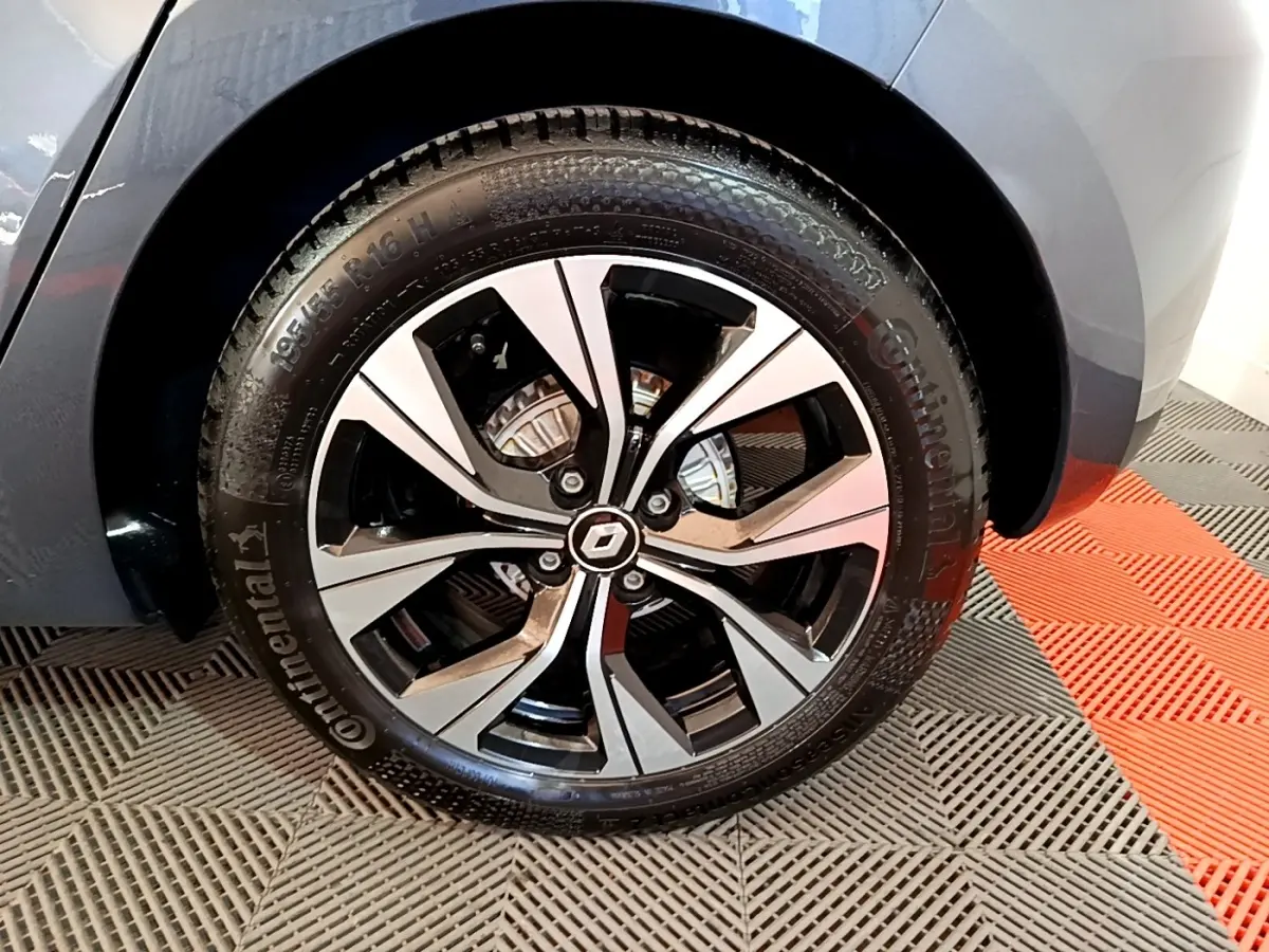 Gros plan sur la roue avant droite gris foncé d’une Renault Clio Evolution SCe 65 avec jante alliage bicolore.