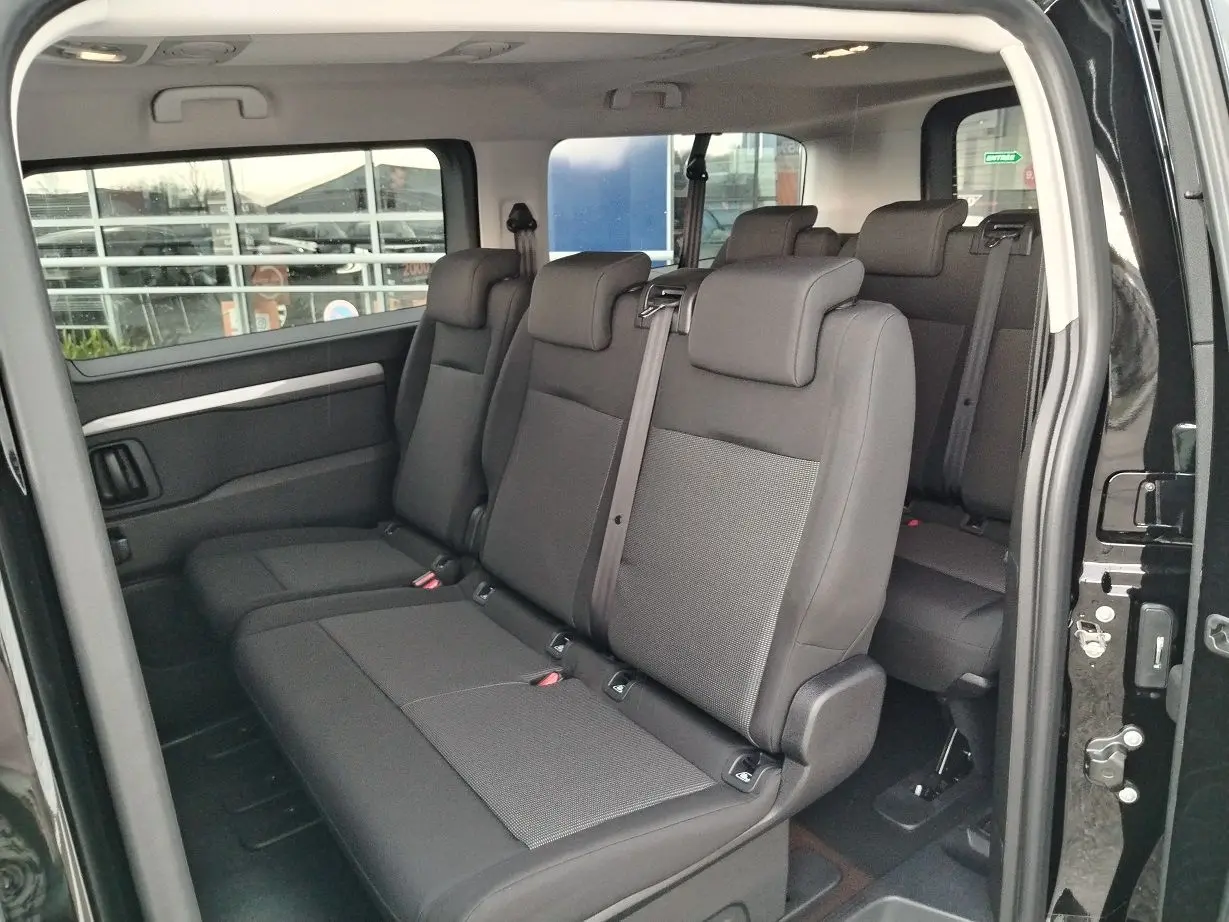 Vue intérieure côté droit du FIAT ULYSSE XL noir Perla, montrant les sièges tissu 9 places avec ceintures de sécurité.