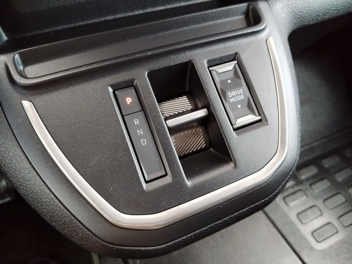 Gros plan sur la console centrale noire du Fiat Ulysse 2026, avec sélecteur de boîte auto et bouton Drive Mode.