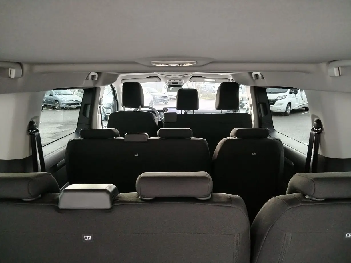 Vue intérieure arrière du Fiat Ulysse XL 2026 noir Perla, montrant les trois rangées de sièges en tissu et les appuie-têtes.