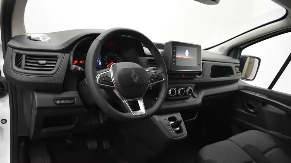 Vue intérieure côté conducteur du Renault Trafic Fourgon blanc 2025, volant multifonction et écran tactile central.