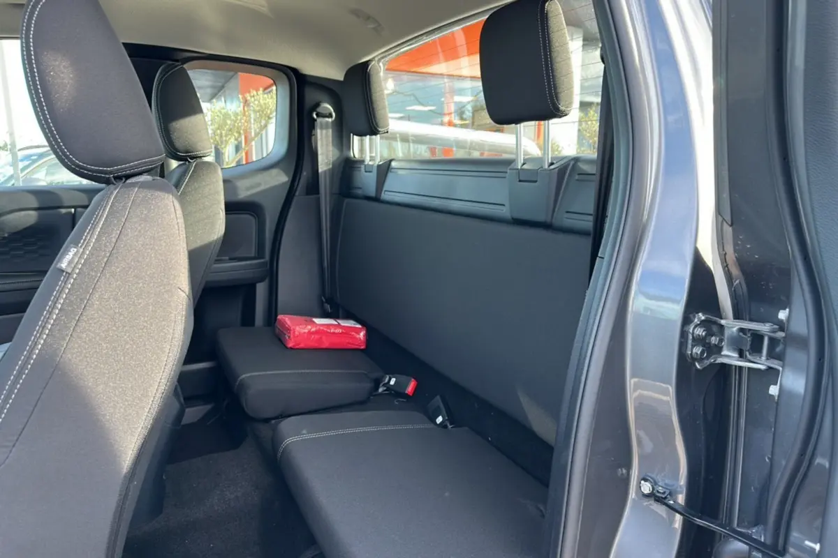 Vue intérieure côté droit sur la banquette arrière noire du Ford Ranger gris carbone avec rideau coulissant fermé.