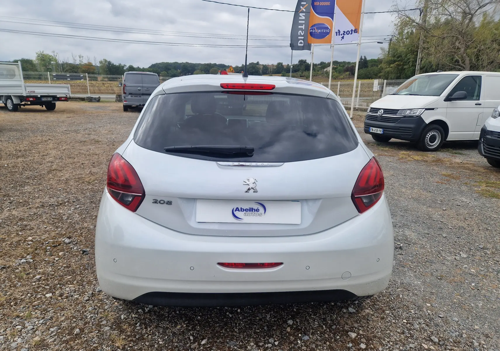 Vue arrière d'une Peugeot 208 blanc nacré de 2018, avec feux arrière rouges et lunette arrière teintée.