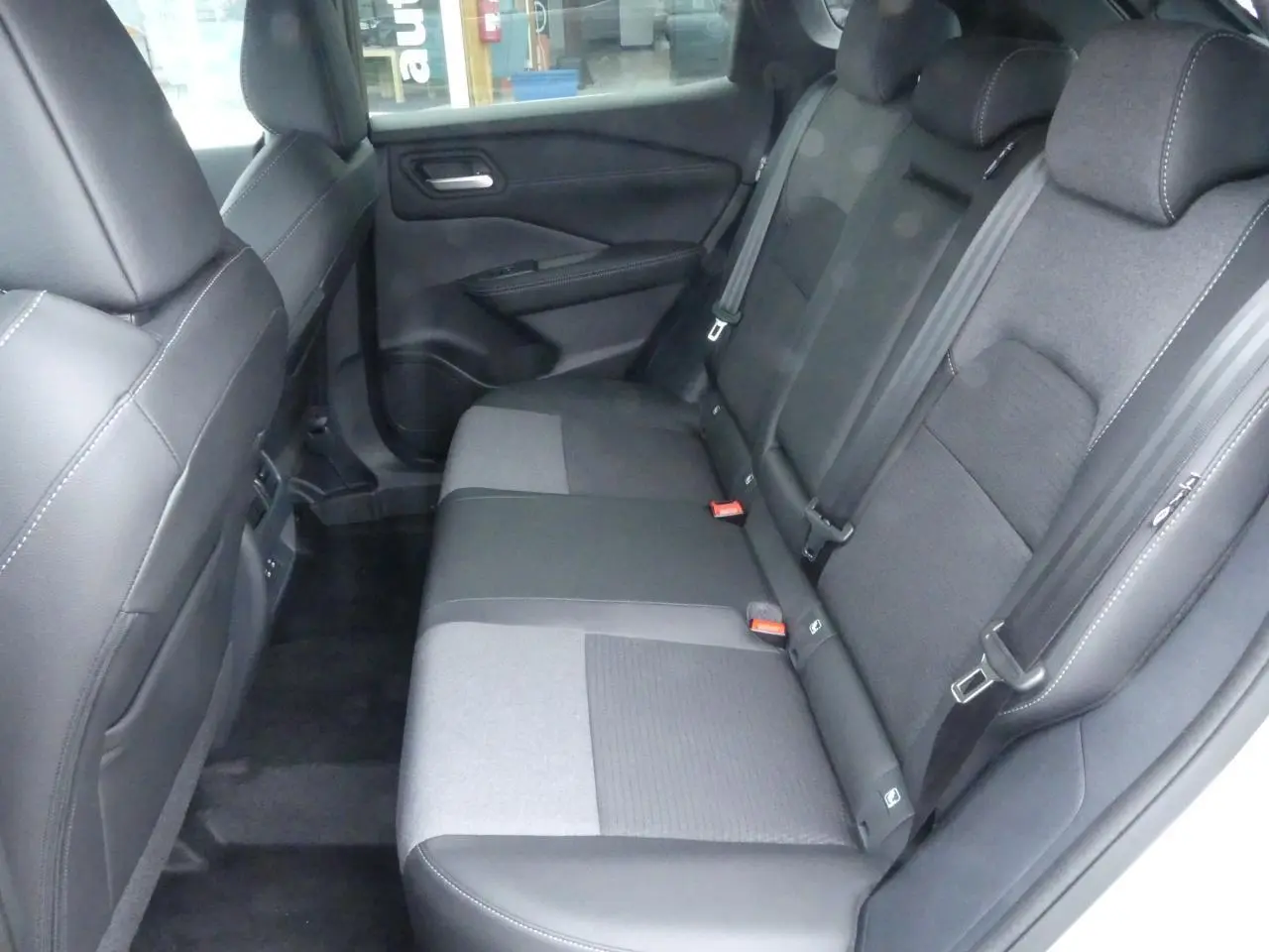 Banquette arrière en tissu noir et gris vue côté droit dans un Nissan Qashqai 2025 gris métallisé.