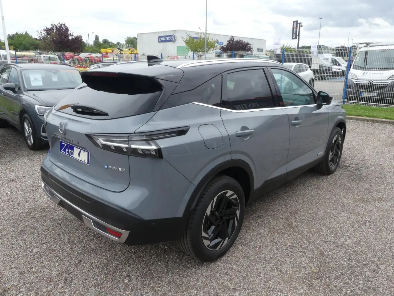 Vue 3/4 arrière droite du Nissan Qashqai 1.5 e-Power gris métallisé avec toit noir et jantes alliage 18 pouces.