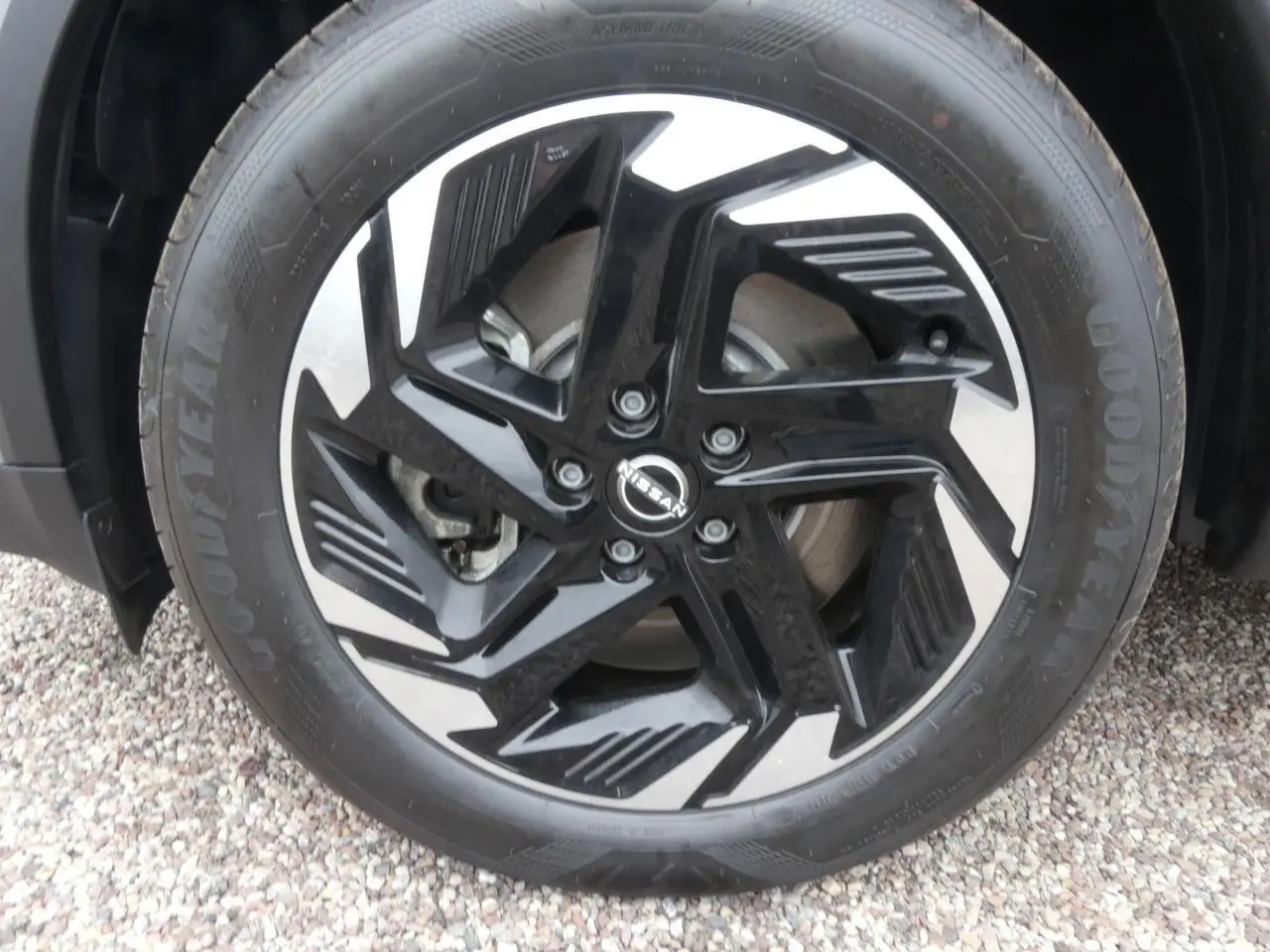 Gros plan sur la jante alliage bicolore noir et argent du Nissan Qashqai 1.5 e-Power gris métallisé.
