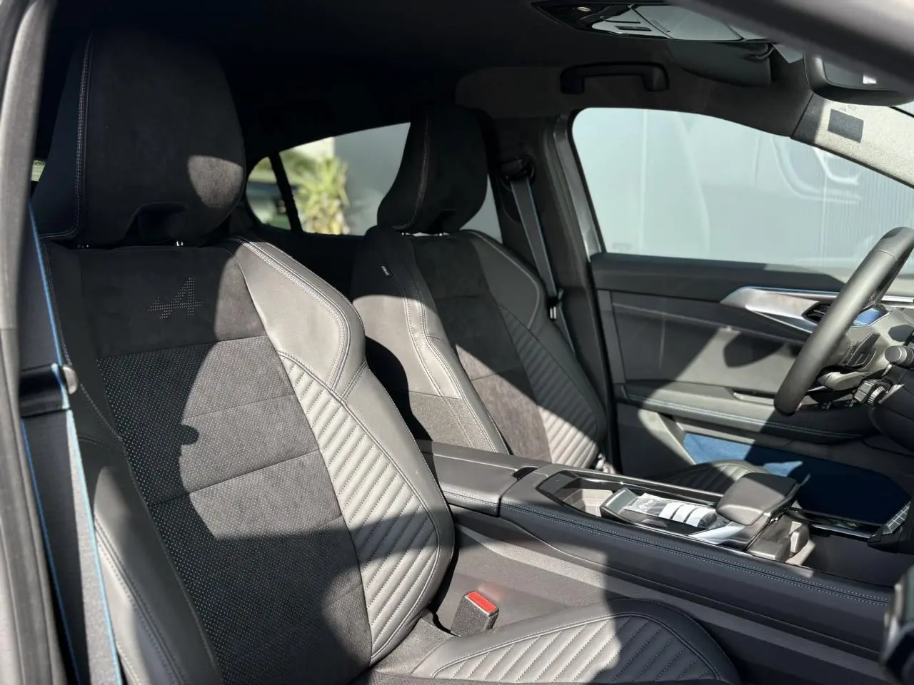 Intérieur avant de la Renault Rafale E-Tech gris schiste, sièges sport avec surpiqûres bleues et console centrale moderne.