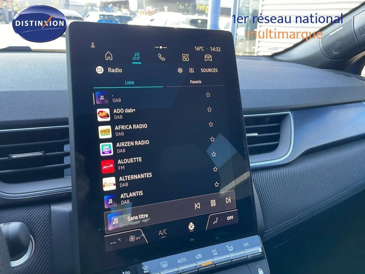 Vue intérieure centrée sur l'écran tactile du tableau de bord du Renault Captur bleu iron metal avec toit noir.