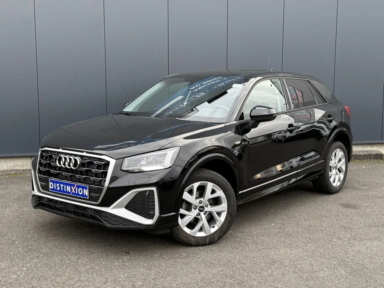 Audi Q2 noir Mythe en 3/4 avant droit, mettant en valeur sa calandre hexagonale et ses jantes alliage 17 pouces.