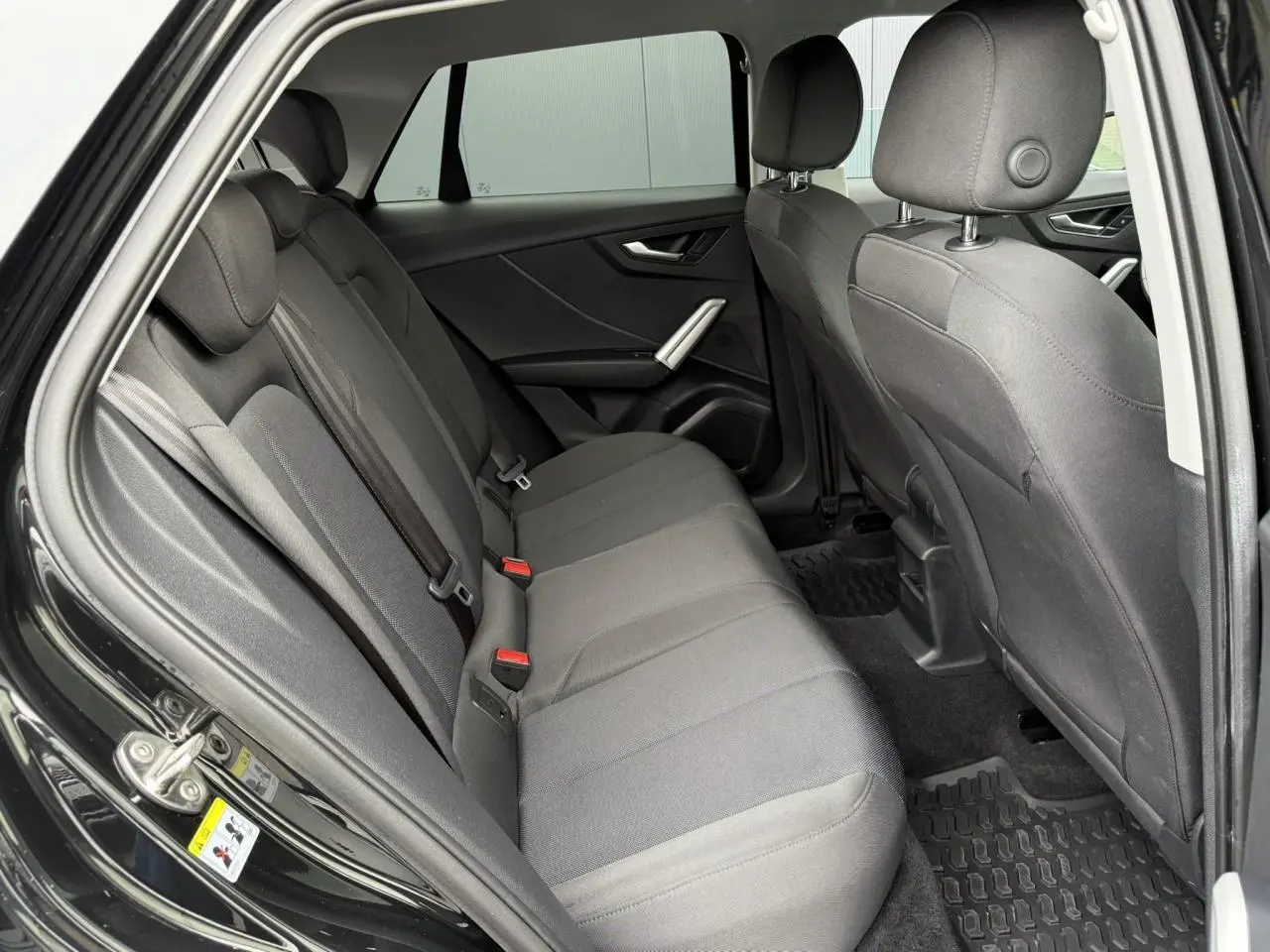 Vue intérieure côté droit des sièges arrière gris foncé de l'Audi Q2 35 TFSI 150 S-Tronic S-Line noir Mythe 2023.