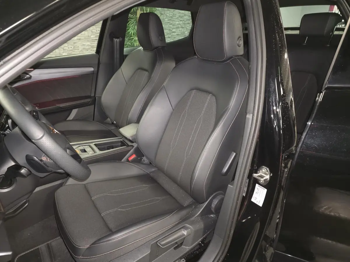 Vue intérieure côté conducteur du CUPRA Formentor noir, sièges sport bimatière avec surpiqûres cuivrées visibles.