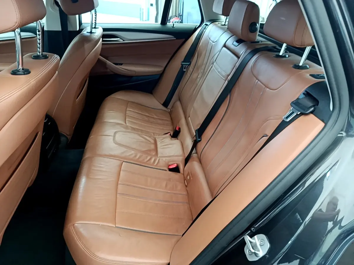 Vue côté droit de la banquette arrière en cuir marron clair d'une BMW Série 5 Touring 530e 2022.