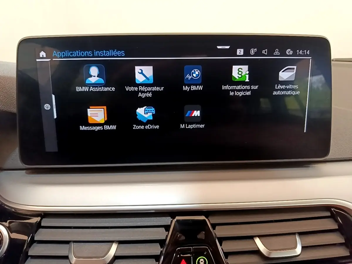Écran tactile central affichant les applications BMW dans l'habitacle d'une BMW Série 5 Touring gris clair.