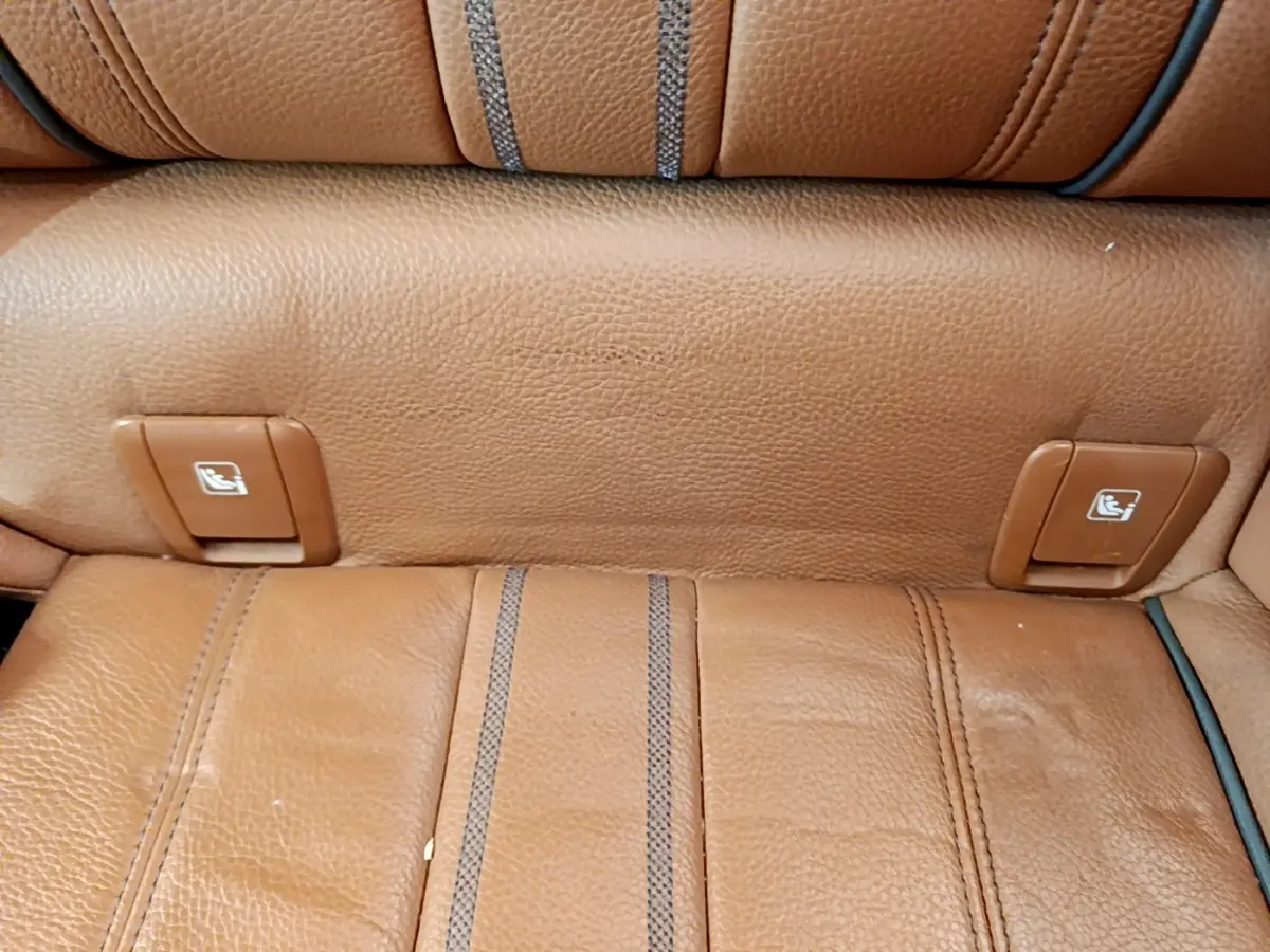Détail des commandes de rabattement des sièges arrière en cuir marron clair dans une BMW Série 5 Touring 530e.