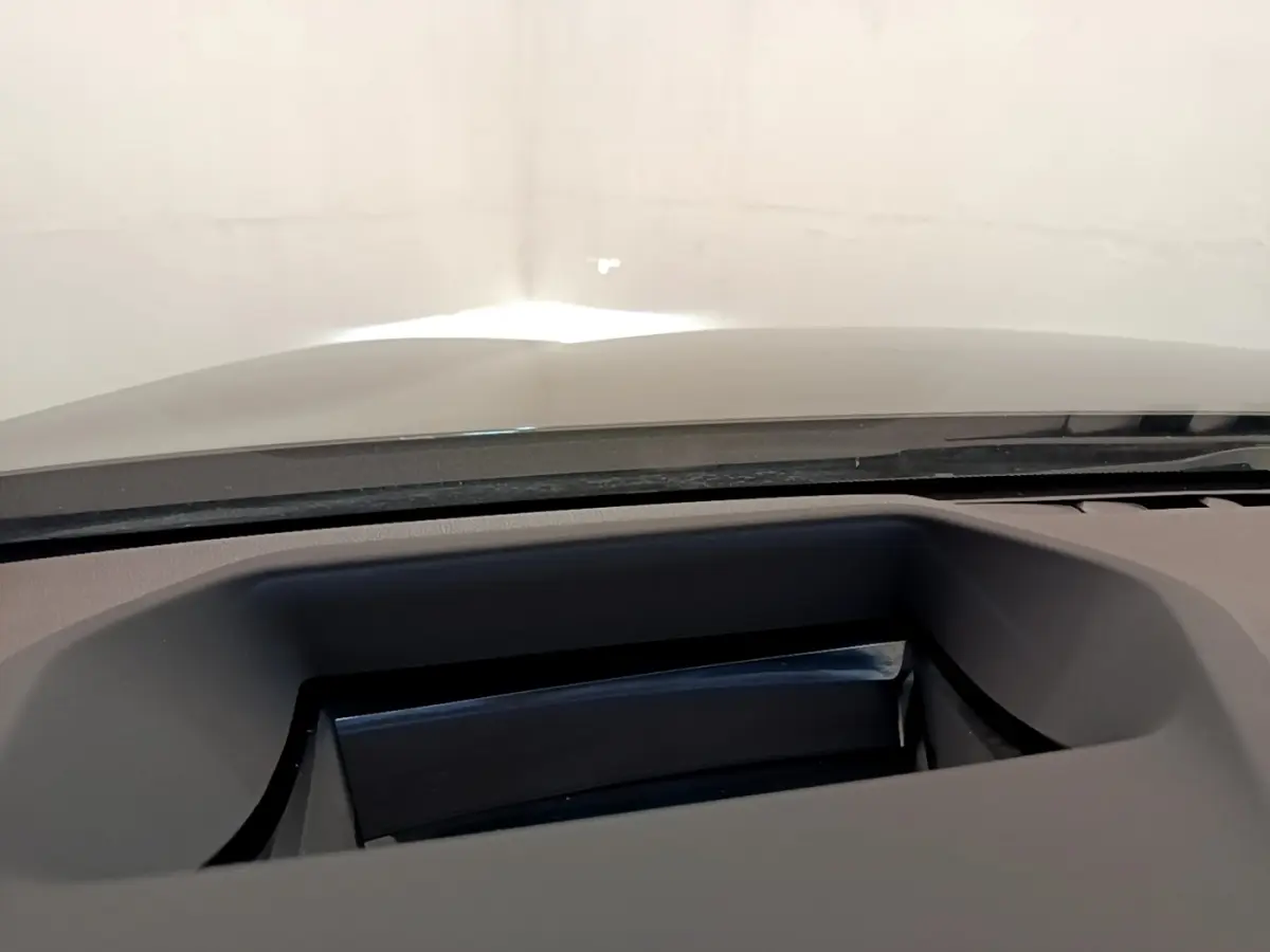 Détail du tableau de bord noir avec affichage tête haute sur BMW Série 5 Touring 530e gris clair.