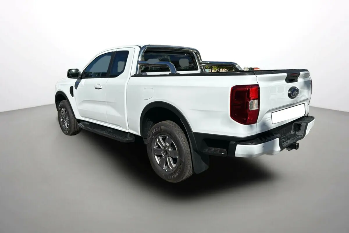 Ford Ranger blanc glacier en 3/4 arrière droit avec arceaux inox et ridelle coulissante visible sur benne.