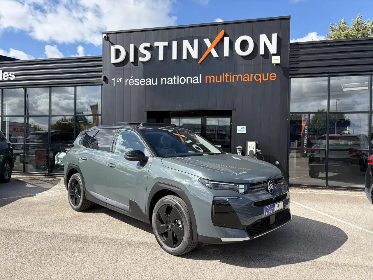 Vue 3/4 avant d’un Citroën C5 Aircross vert Astoria avec toit noir, jantes noires et calandre distinctive.