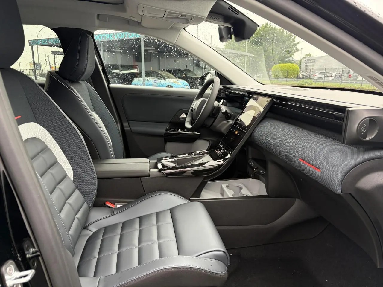 Vue intérieure côté conducteur du Citroën C5 Aircross 2026, sellerie noire avec inserts gris et tableau de bord moderne.