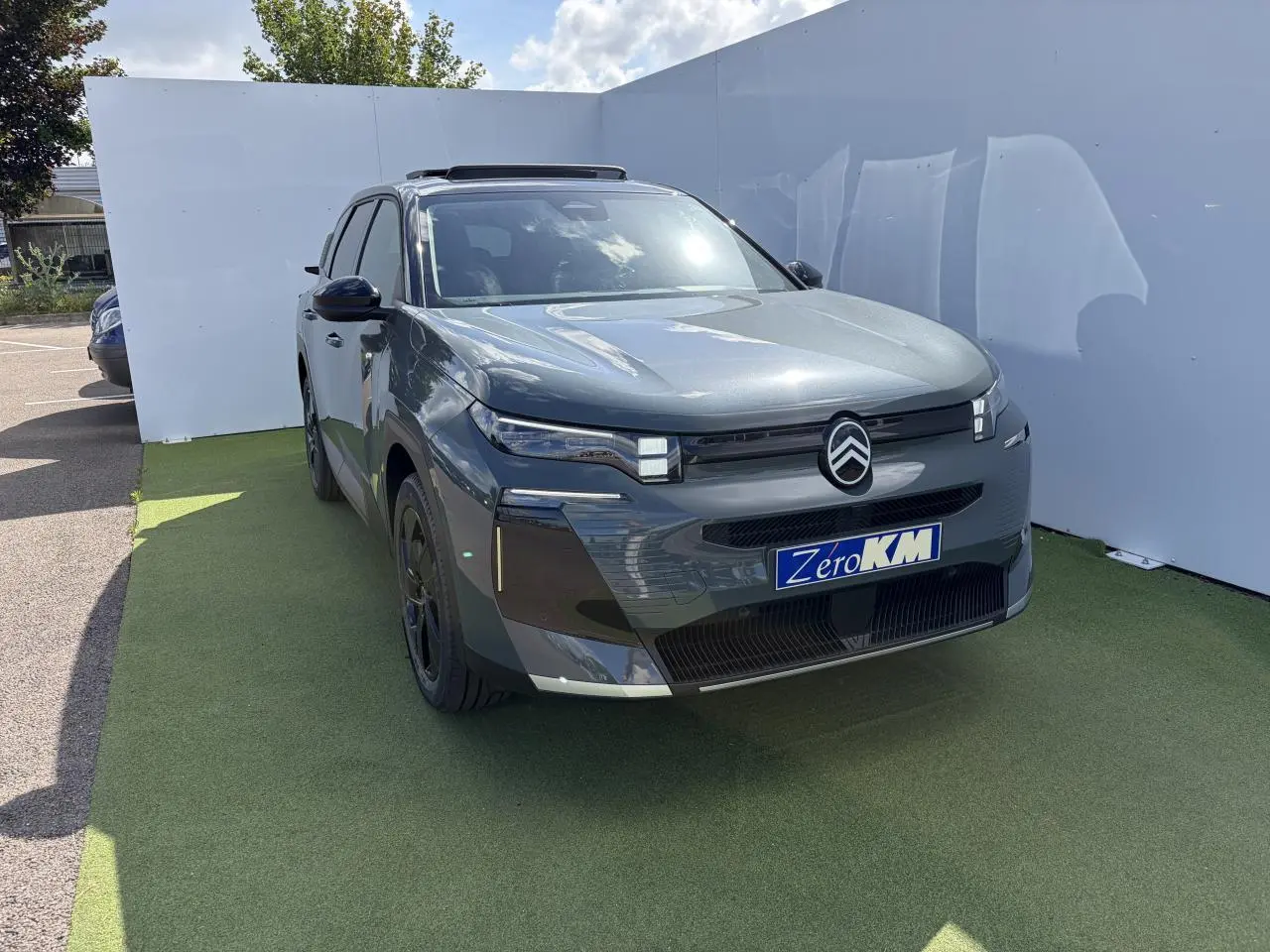 Vue 3/4 avant gauche d'une Citroën C5 Aircross 2026 vert Astoria avec toit noir et calandre distinctive.