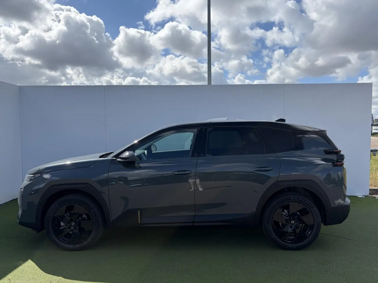 Profil latéral gauche du Citroën C5 Aircross 2026 vert Astoria avec toit noir et jantes alliage noires.