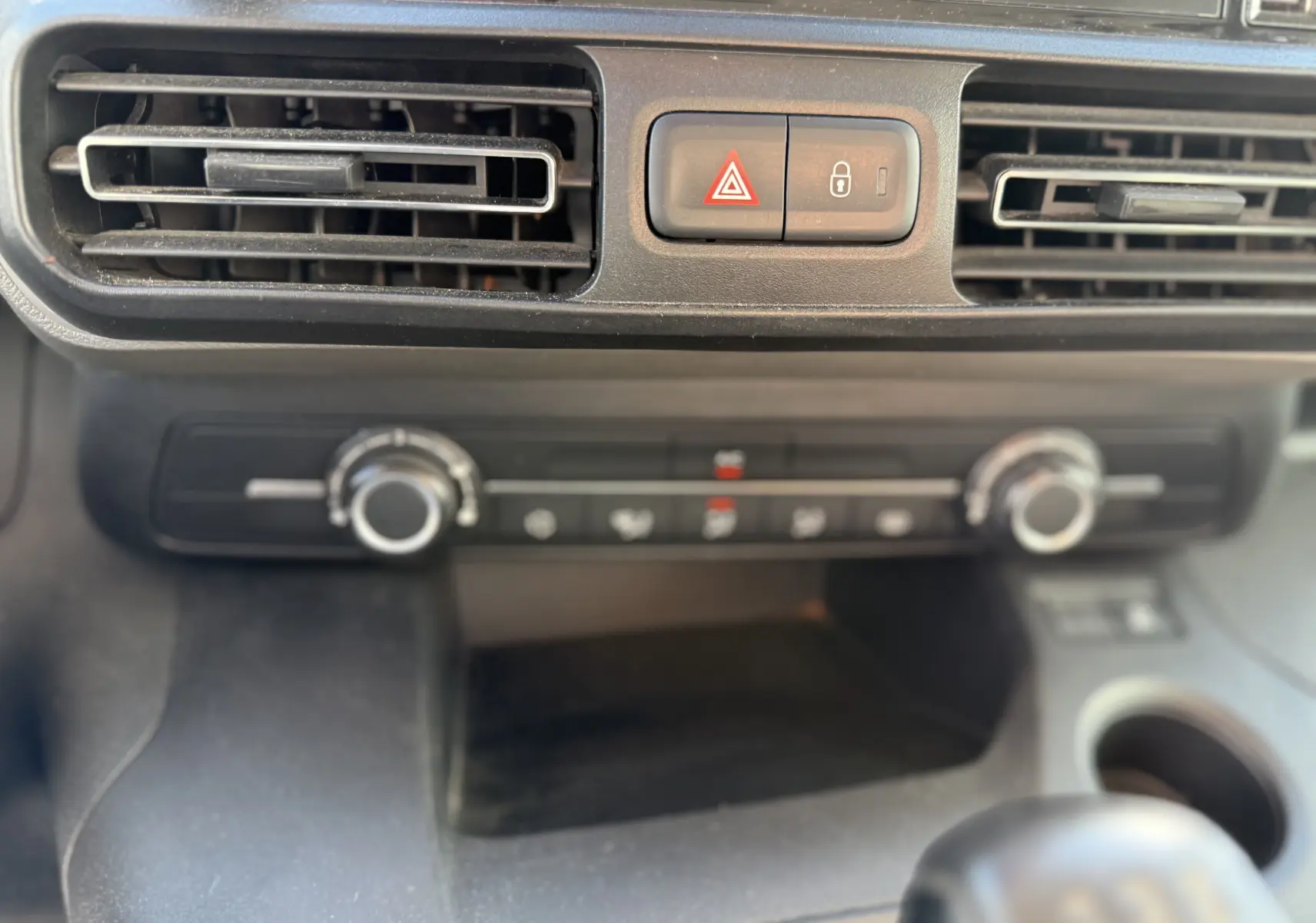 Gros plan sur la console centrale du Peugeot Rifter 2019, montrant les aérateurs et commandes de climatisation.