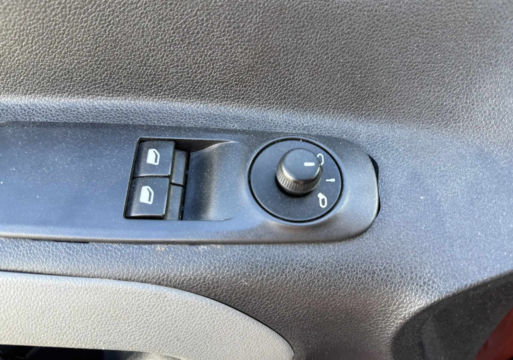 Gros plan sur les commandes de réglage des rétroviseurs et des vitres électriques côté conducteur du Peugeot Rifter Copper Metallic.