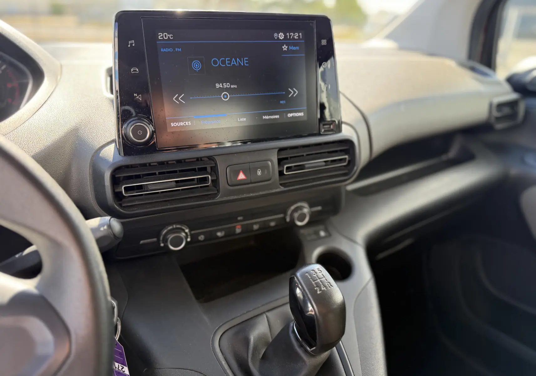 Vue intérieure du tableau de bord du Peugeot Rifter 2019, avec écran tactile et levier de vitesse manuel visible.