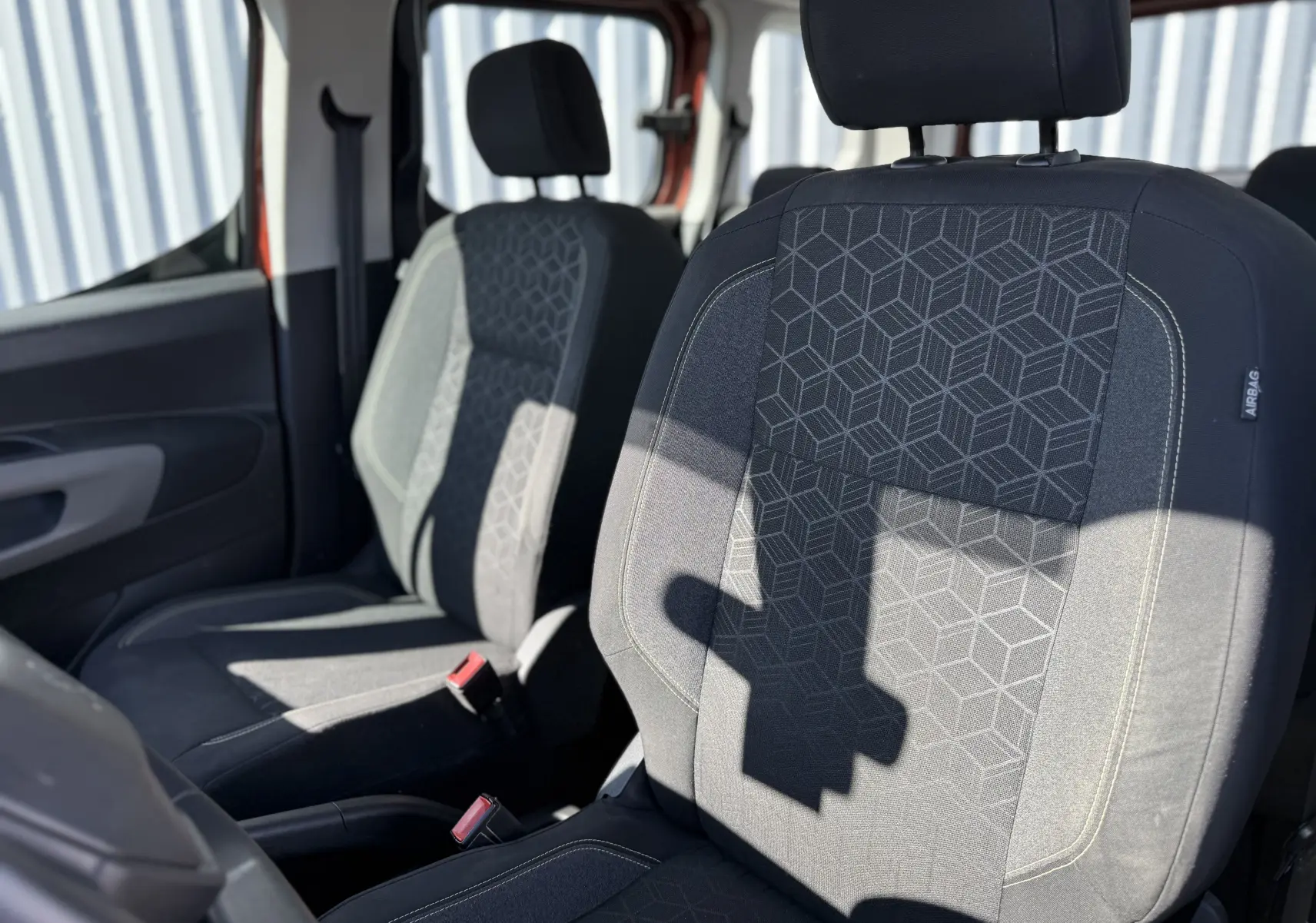 Vue rapprochée des sièges avant en tissu gris avec motifs géométriques du Peugeot Rifter Copper Metallic 2019.