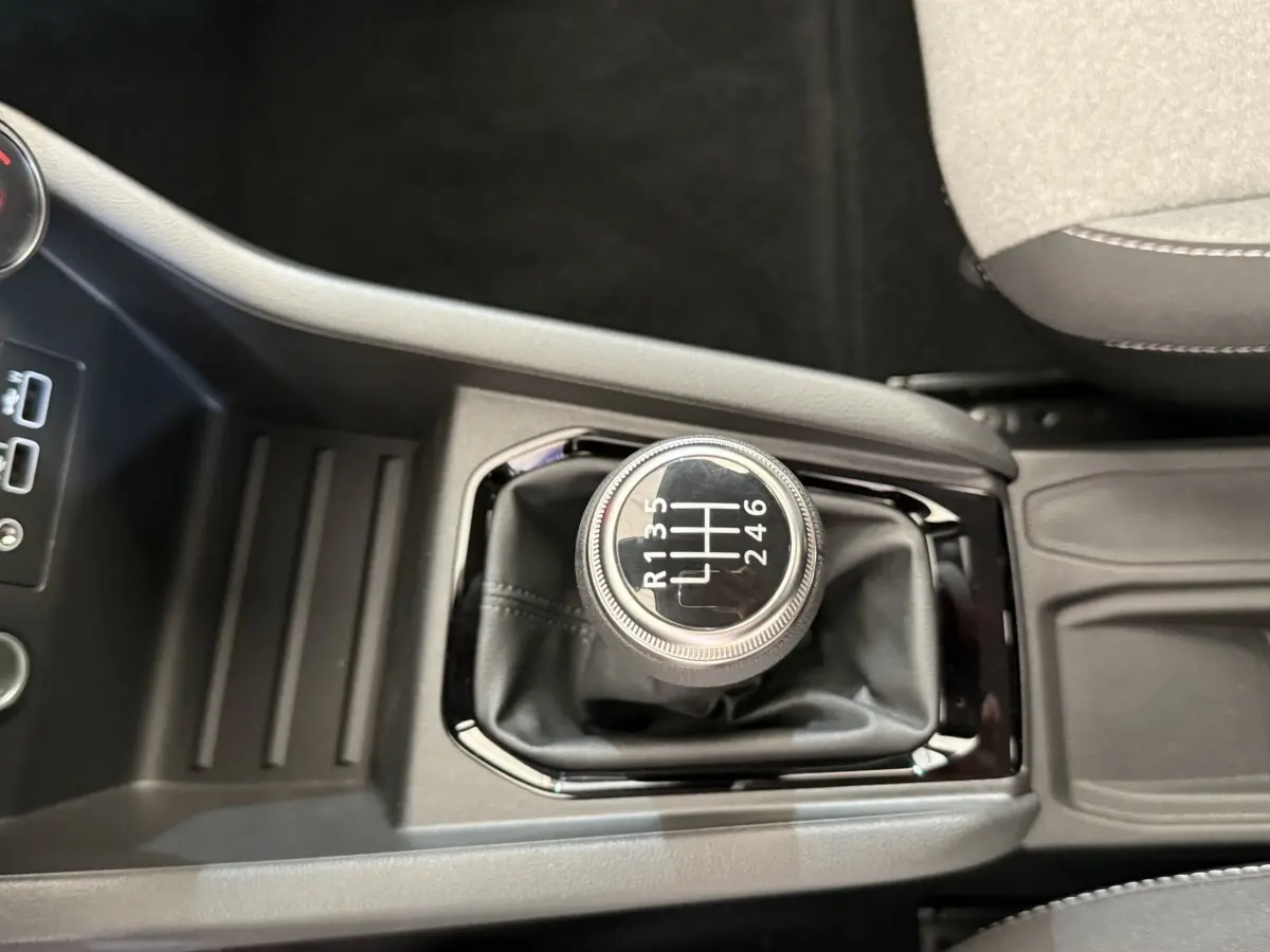 Vue rapprochée du levier de vitesses manuel noir au centre de la console d'une Renault Clio Evolution Blue dCi 100 2025.
